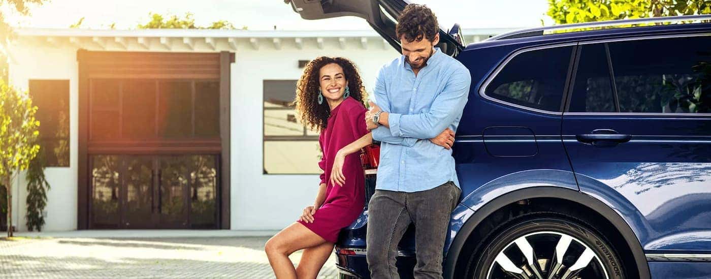 A couple stands by the trunk of a 2021 Volkswagen Tiguan