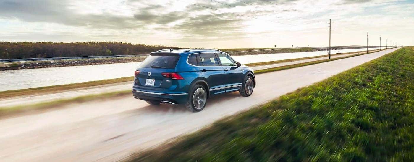 Blue 2021 Volkswagen Tiguan driving by water