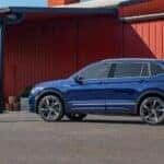 Blue 2023 Volkswagen Tiguan parked outside a red building