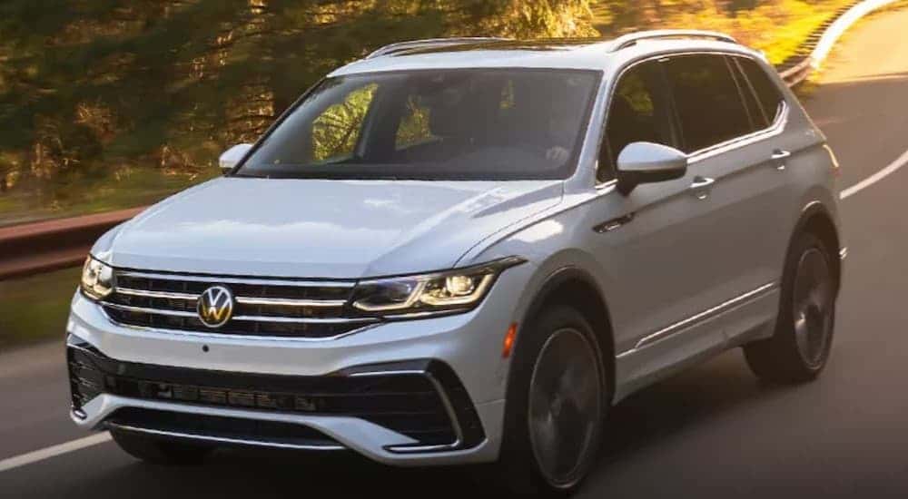 A white 2023 Volkswagen Tiguan driving on a highway.