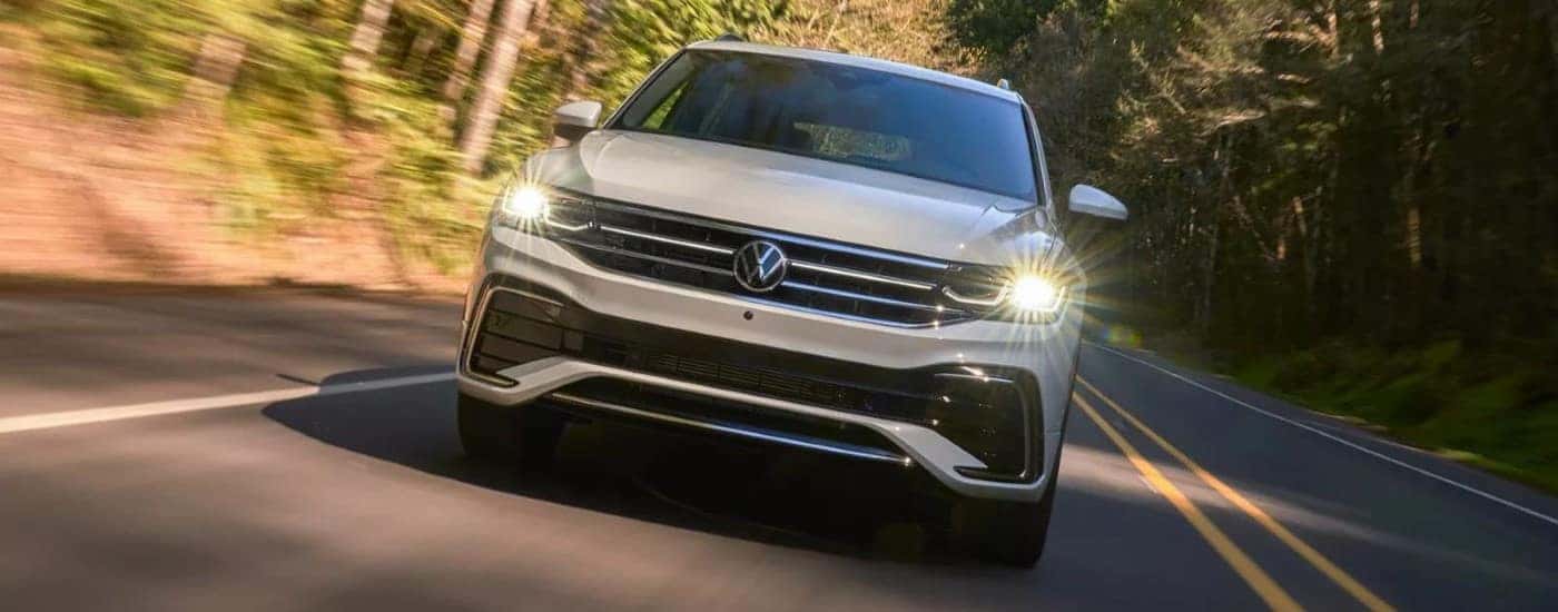 A white 2023 Volkswagen Tiguan driving down a road