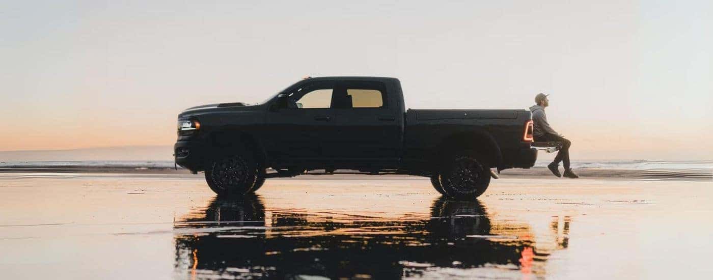 Side profile of a black 2022 Ram 2500 for sale parked by the ocean