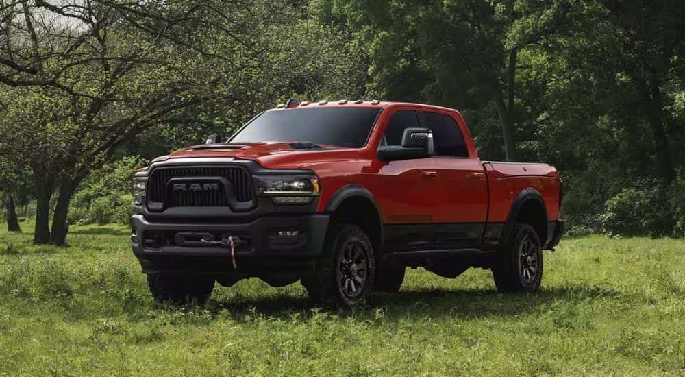 A red 2023 Ram 2500 Power Wagon parked off-road on grass