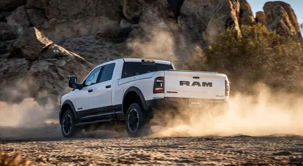 A white 2024 Ram 2500 off-roading in dirt