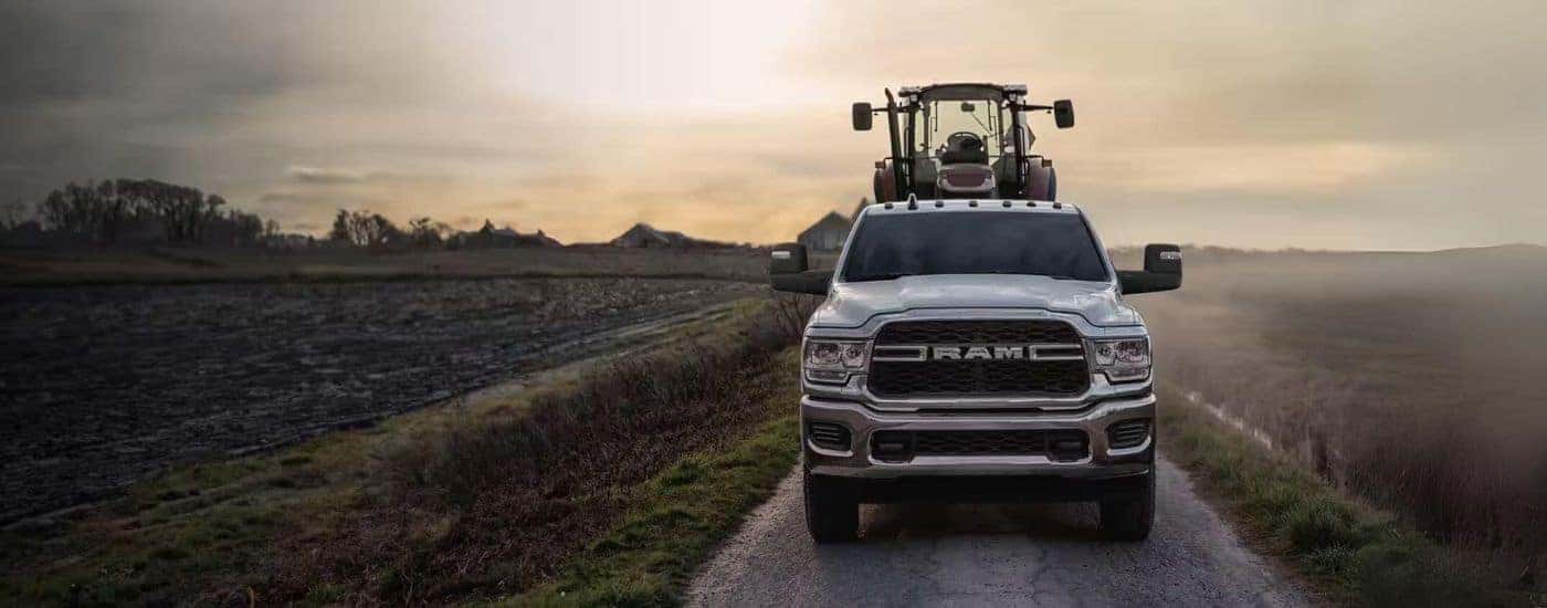 Silver 2024 Ram 2500 towing a tractor