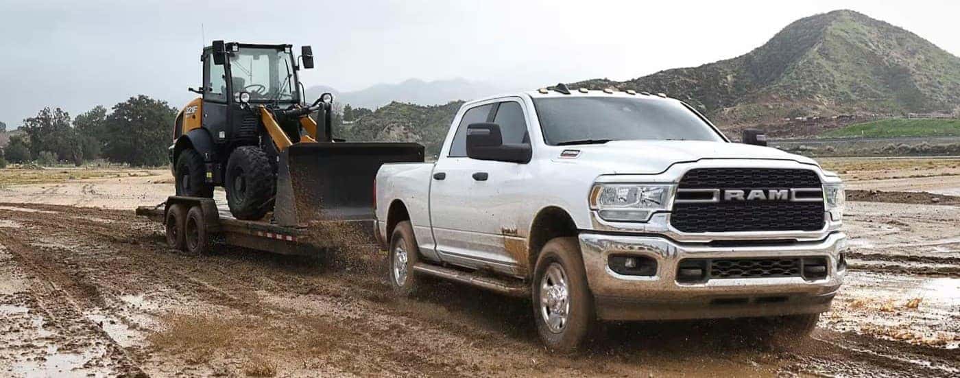 A white 2023 Ram 2500 for sale in Nashville towing a trailer.