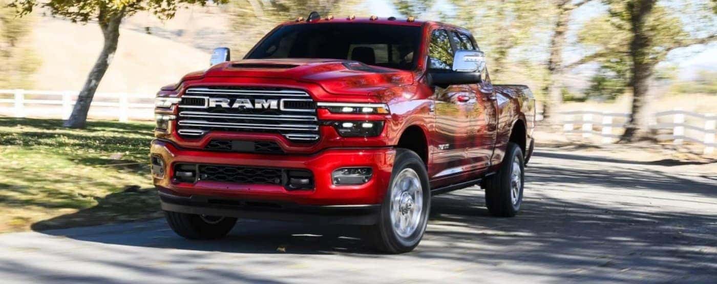 A red 2026 Ram 2500 driving on a backroad.