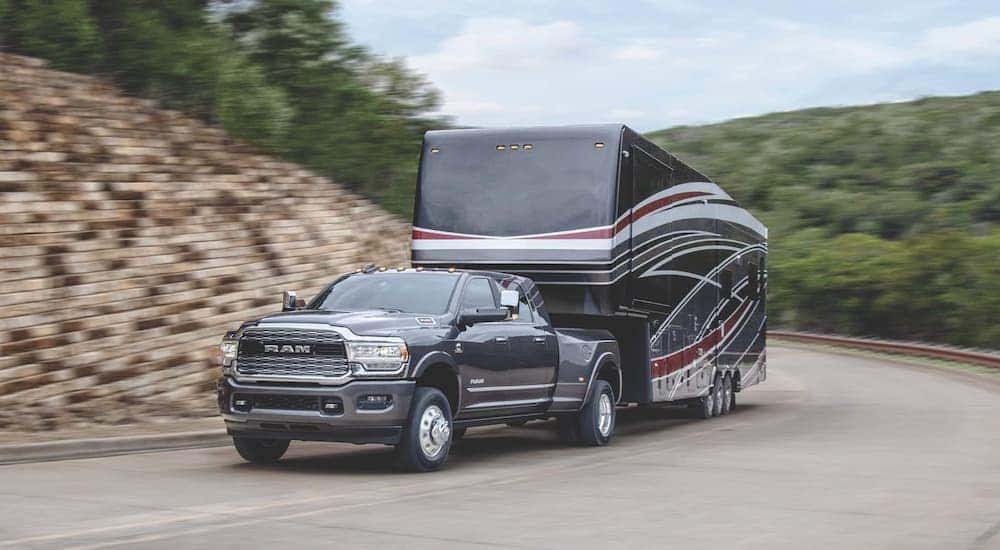 Black 2020 Ram 3500 towing a camper van.