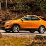 Orange 2019 Chevy Equinox driving down a road.