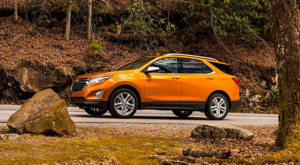 Orange 2019 Chevy Equinox driving down a road.