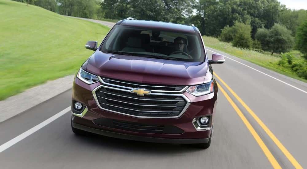 Front of a red 2020 Chevy Traverse driving down a road.
