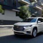 White 2020 Chevy Traverse driving down a road.