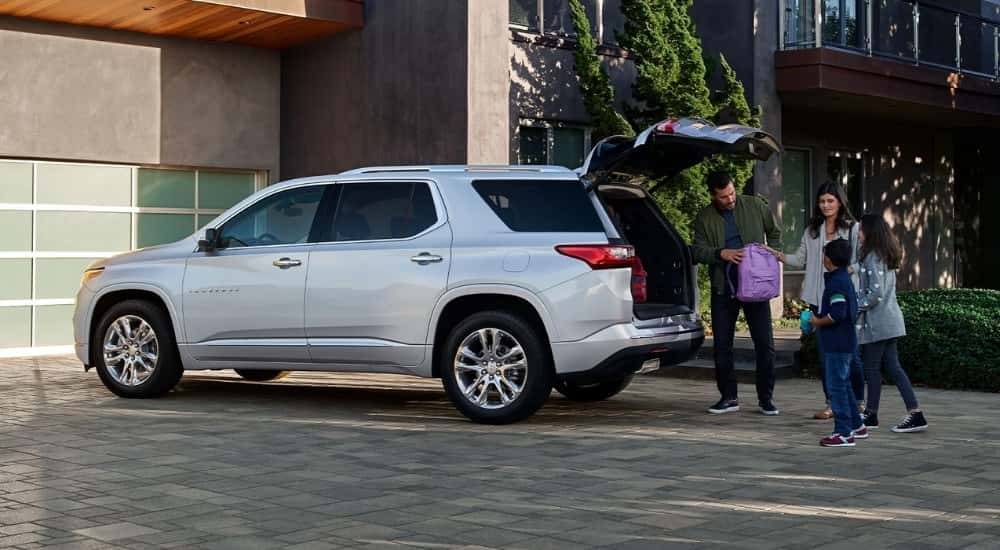 Rear of a white 2022 Chevy Traverse with an open hatch parked on a driveway.