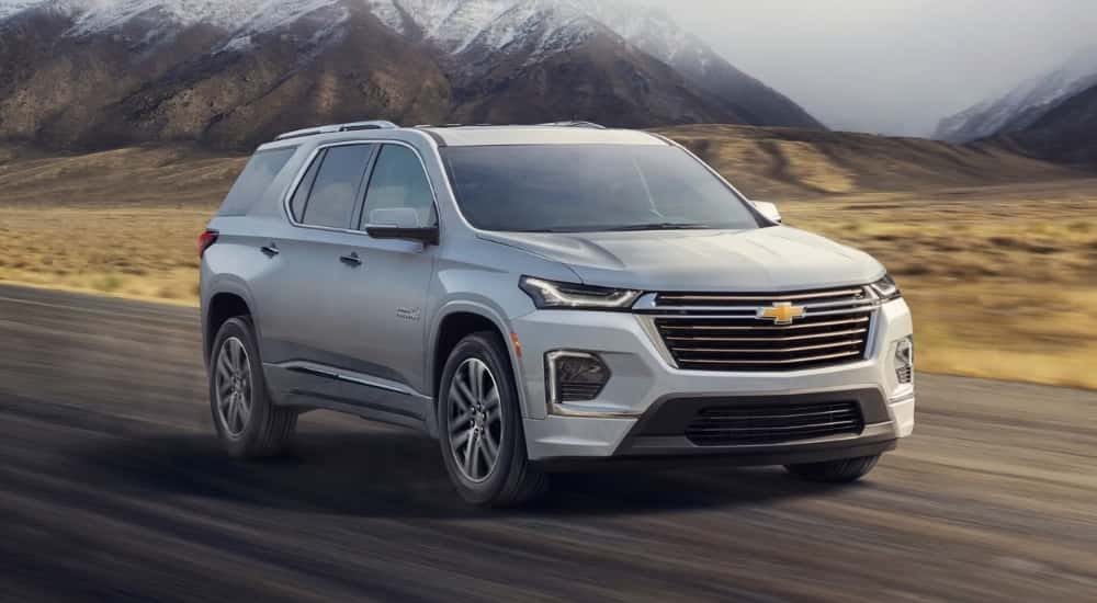 White 2022 Chevy Traverse driving down a road.
