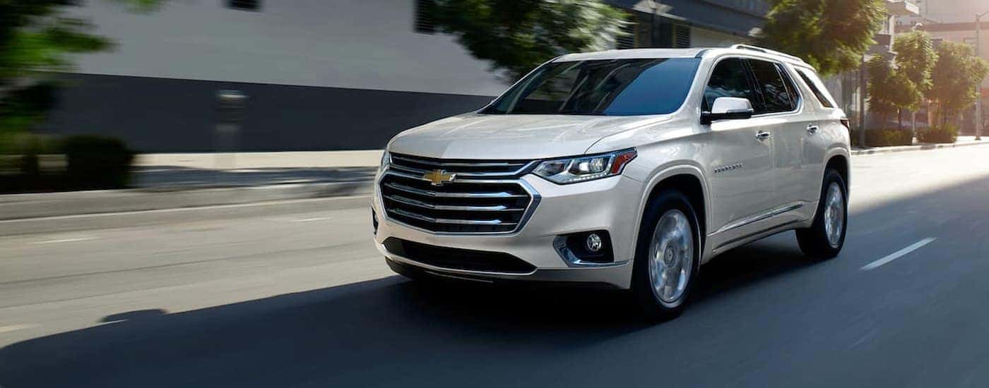 A white 2020 Chevy Traverse driving in a city