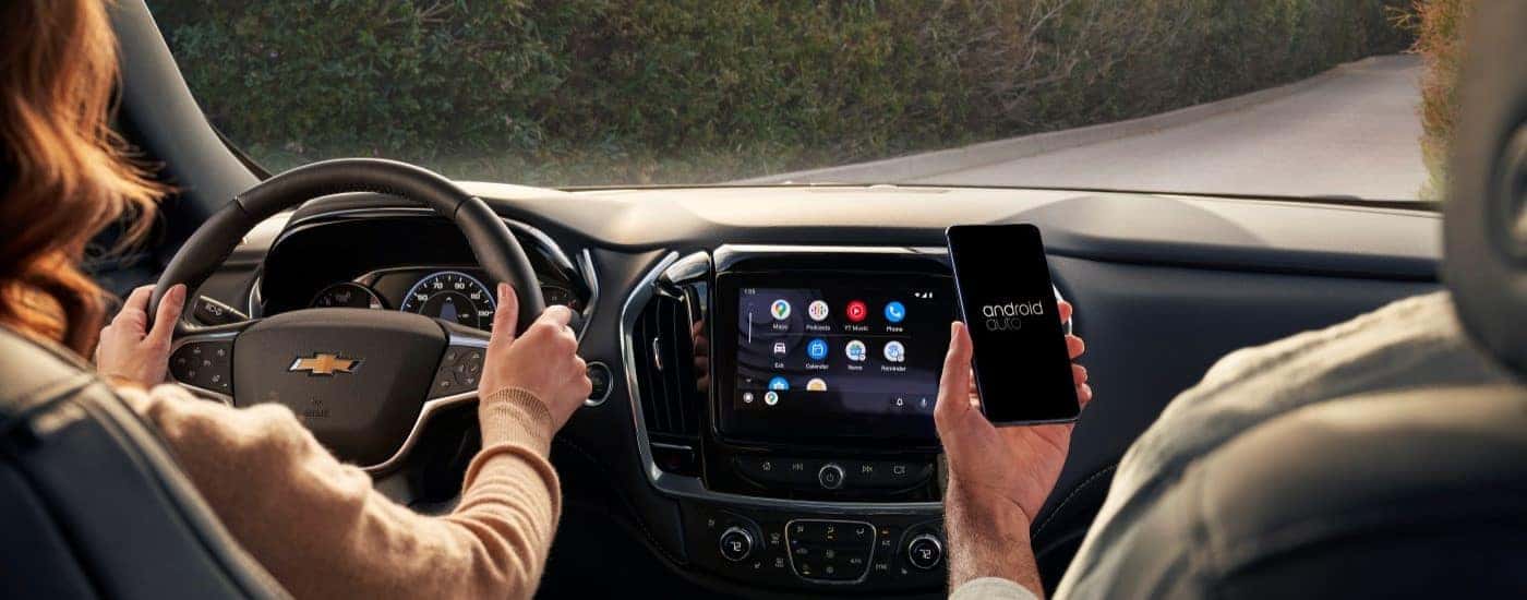 People using the tech features inside a 2022 Chevy Traverse