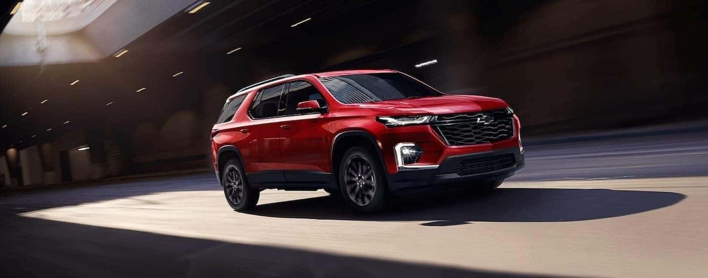 A red 2022 Chevy Traverse for sale driving in a city