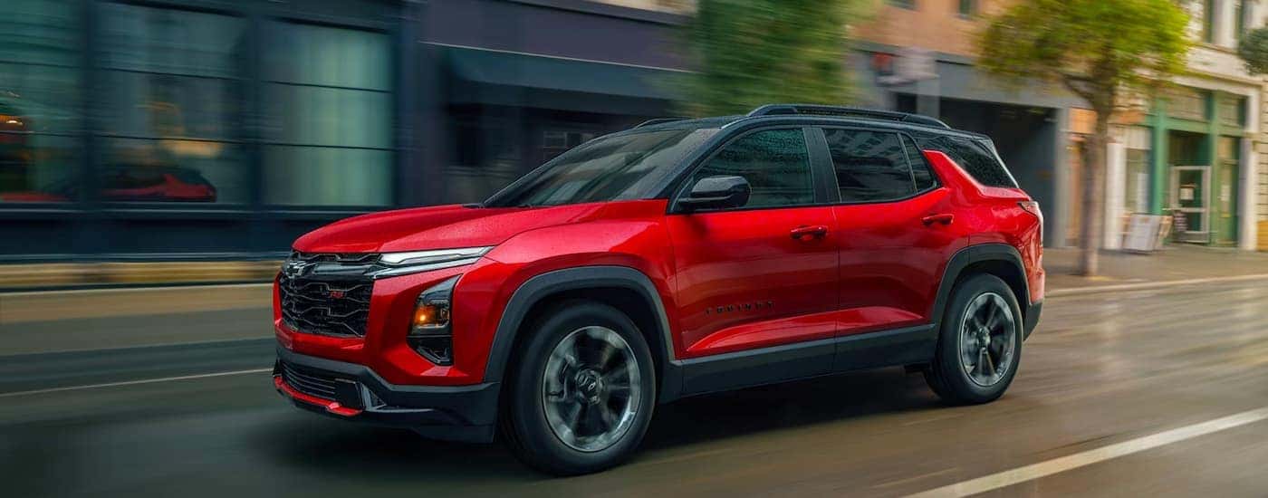 A red 2026 Chevy Equinox driving in a city