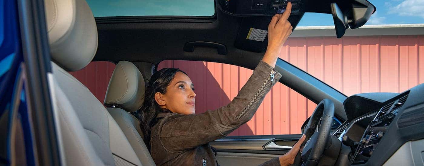 Person opening a moonroof in a 2022 Volkswagen Tiguan
