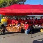 Group of employees in red shirts with gift bags ready