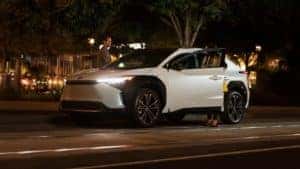 White Toyota RAV4 Prime XSE at night with headlights on
