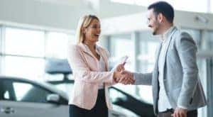 A salesperson is shown talking to someone about valuing their trade.