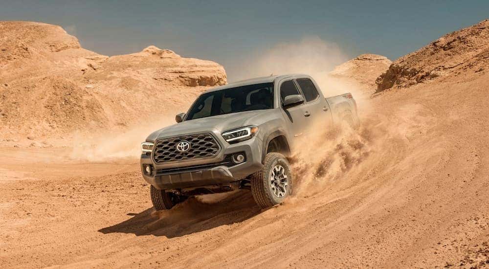 Tan 2020 Toyota Tacoma TRD off-roading down a hill.
