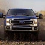 A blue 2022 Ford F-250 is shown from the front off-roading.