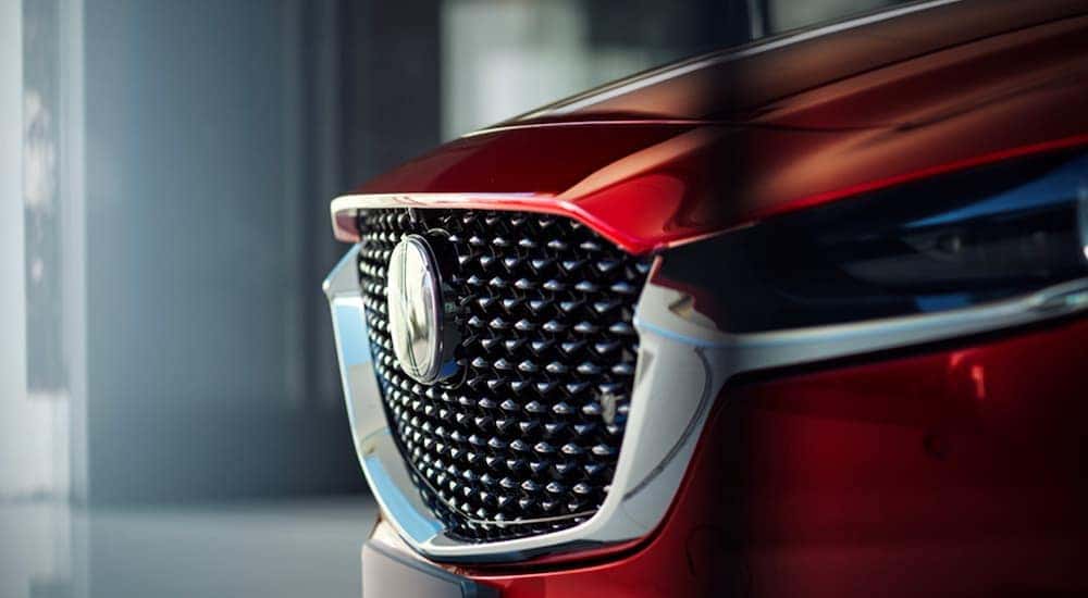 Close-up of the grille and badge of a red 2021 Mazda CX-30.