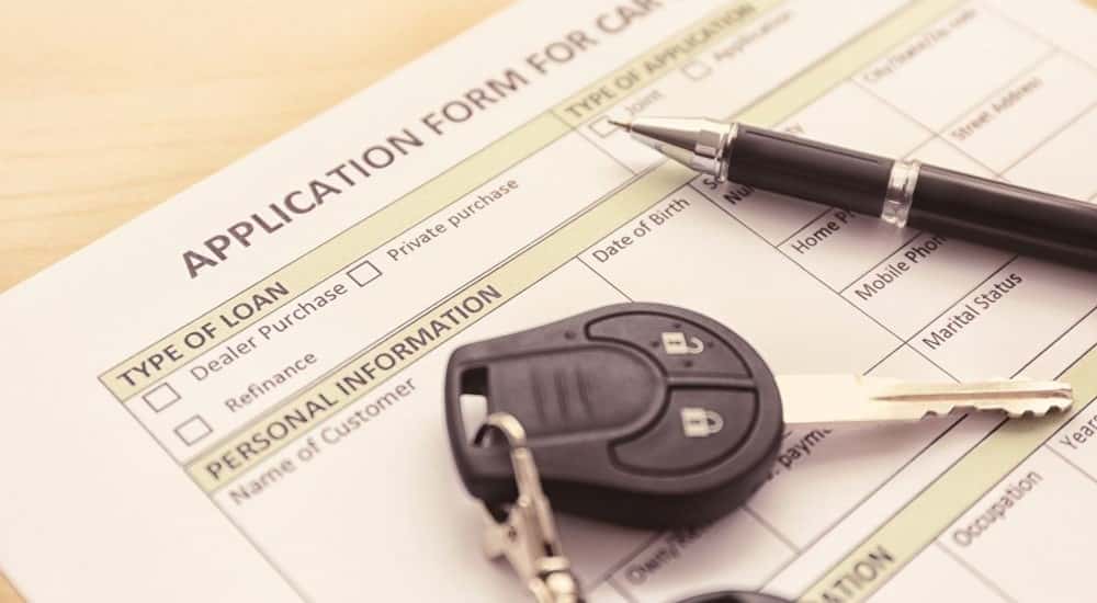 Key fob and a pen on a car loan application.