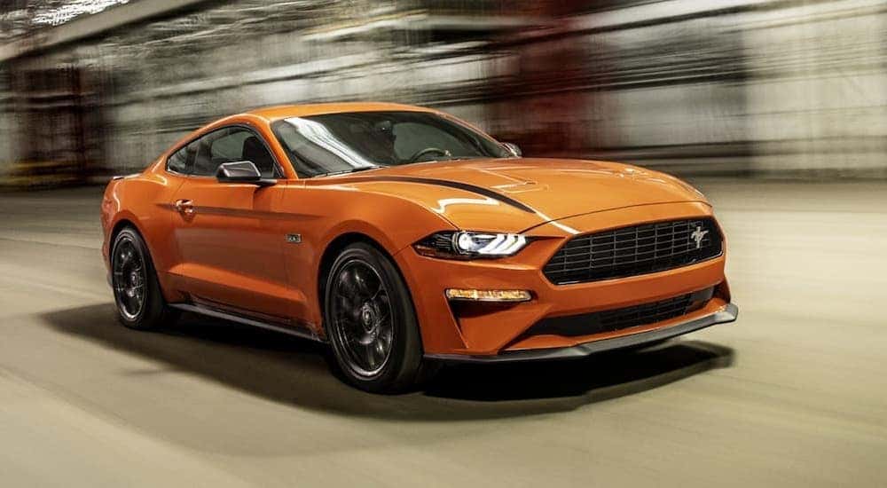Orange 2021 Ford Mustang Ecoboost HPP driving through a tunnel.