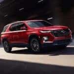 A red 2023 Chevy Traverse RS is shown from the front at an angle after leaving a used car dealership near Colonie.