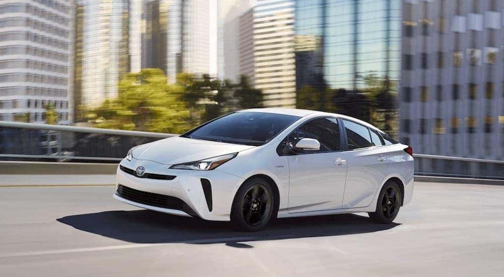 White 2020 Toyota Prius driving down a road.