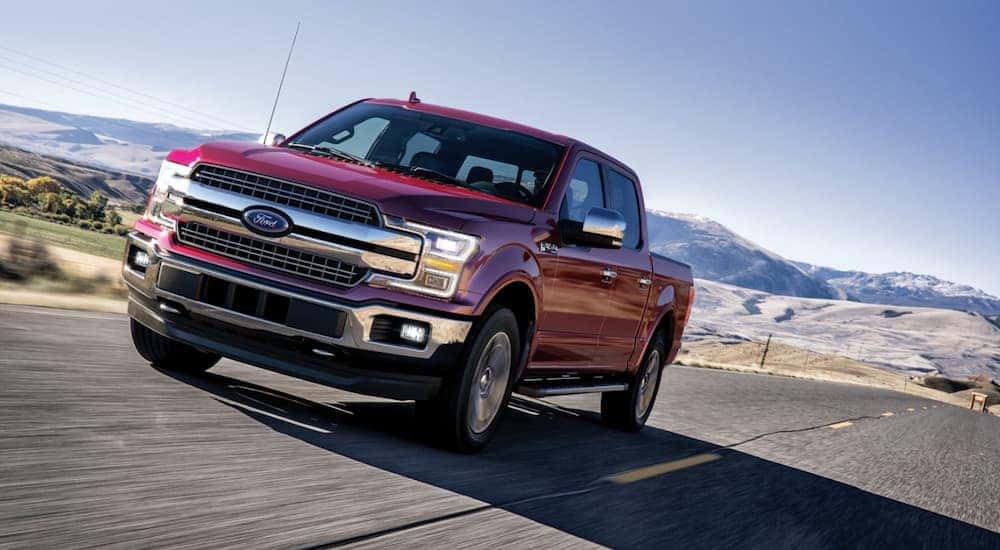 Red 2020 Ford F-150 driving down a road.