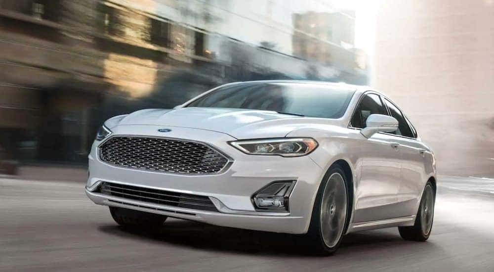 White 2020 Ford Fusion driving on a city street.