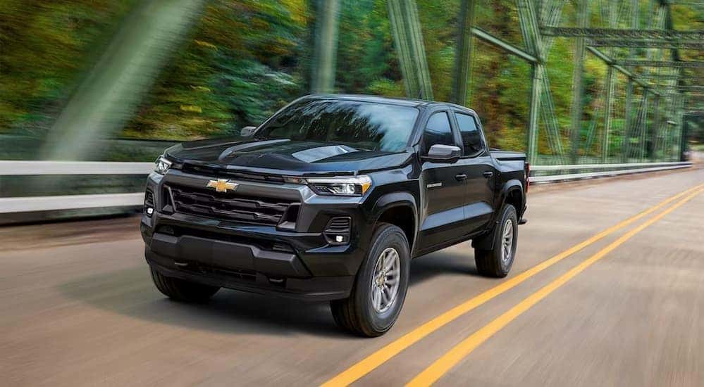 Black 2023 Chevy Colorado driving on a bridge.
