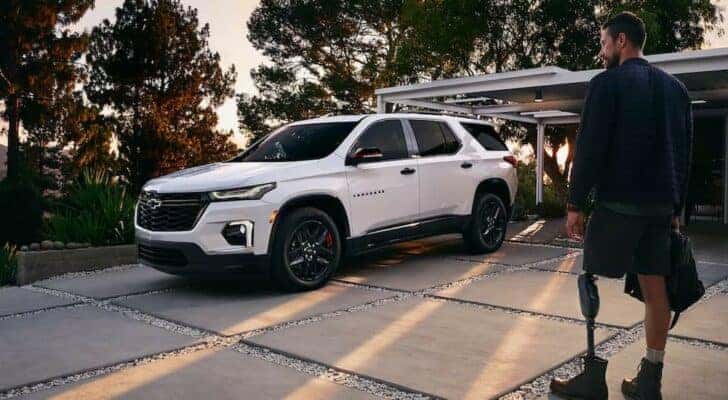 One of many popular CPO Chevys for sale, a white 2023 Chevy Traverse, is shown parked on a driveway.