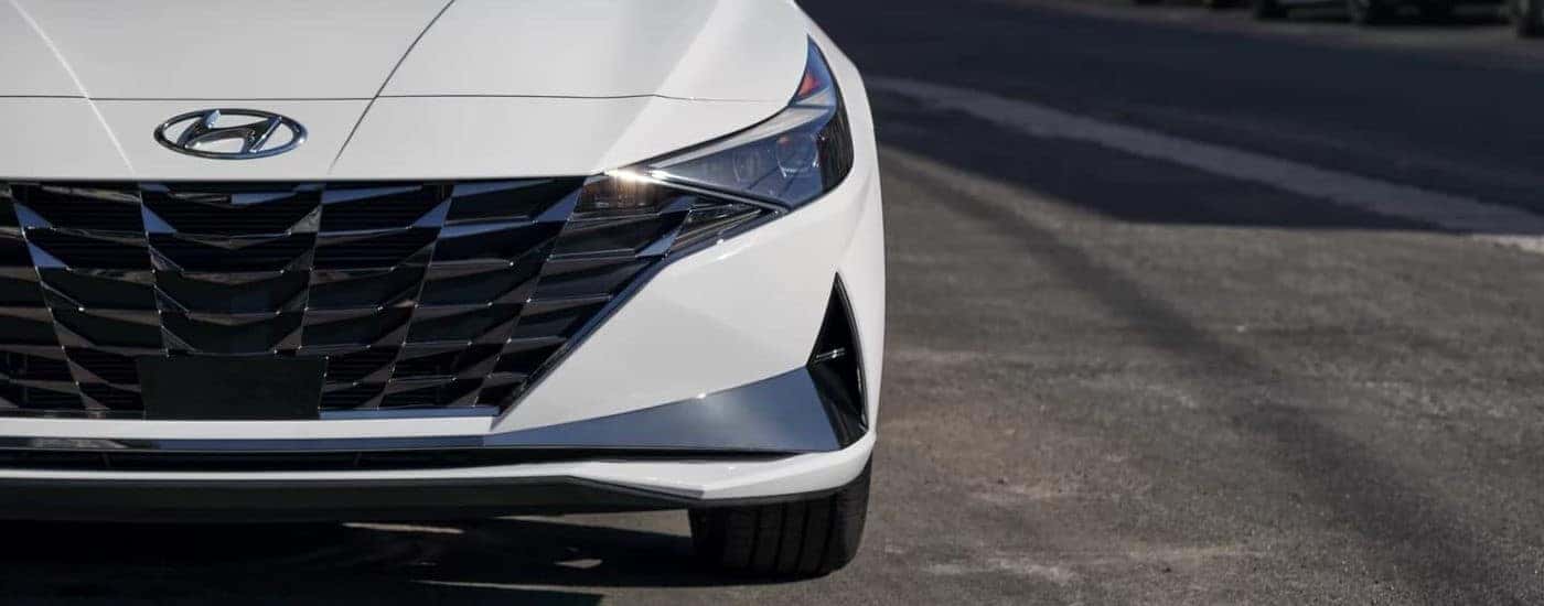 Headlight and grille on a white 2021 Hyundai Elantra Hybrid.