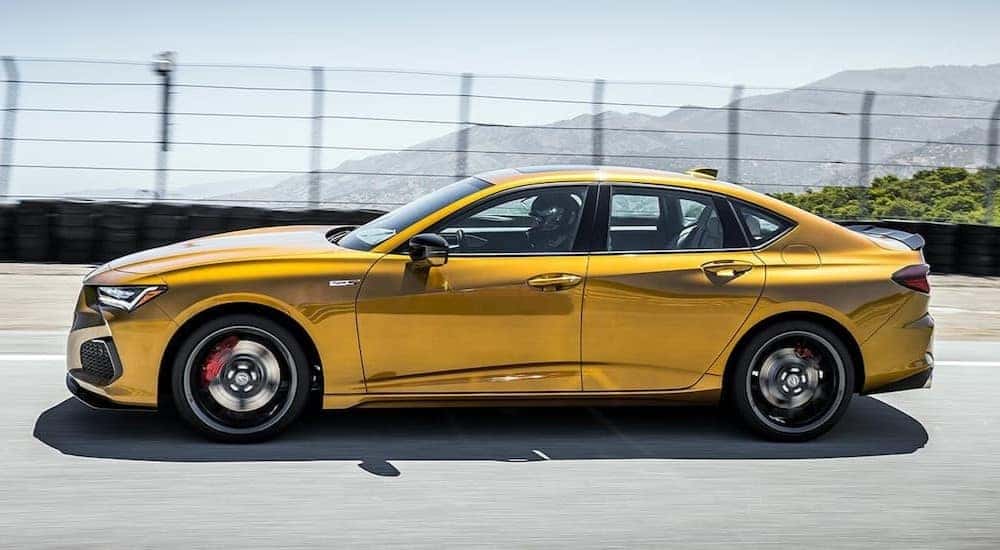 A golden 2021 Acura TLX Type-S is shown driving on a track.