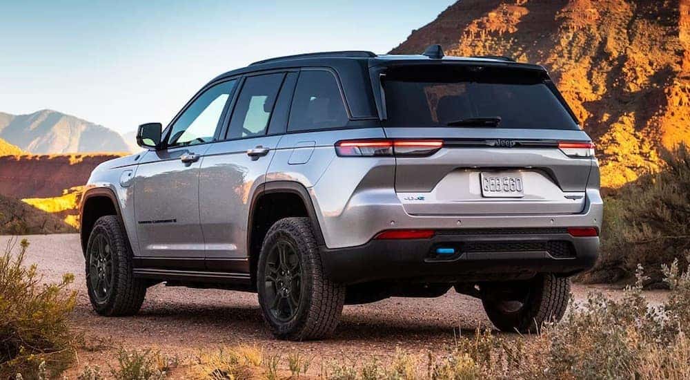 Silver 2022 Jeep Grand Cherokee 4xe parked off-road.