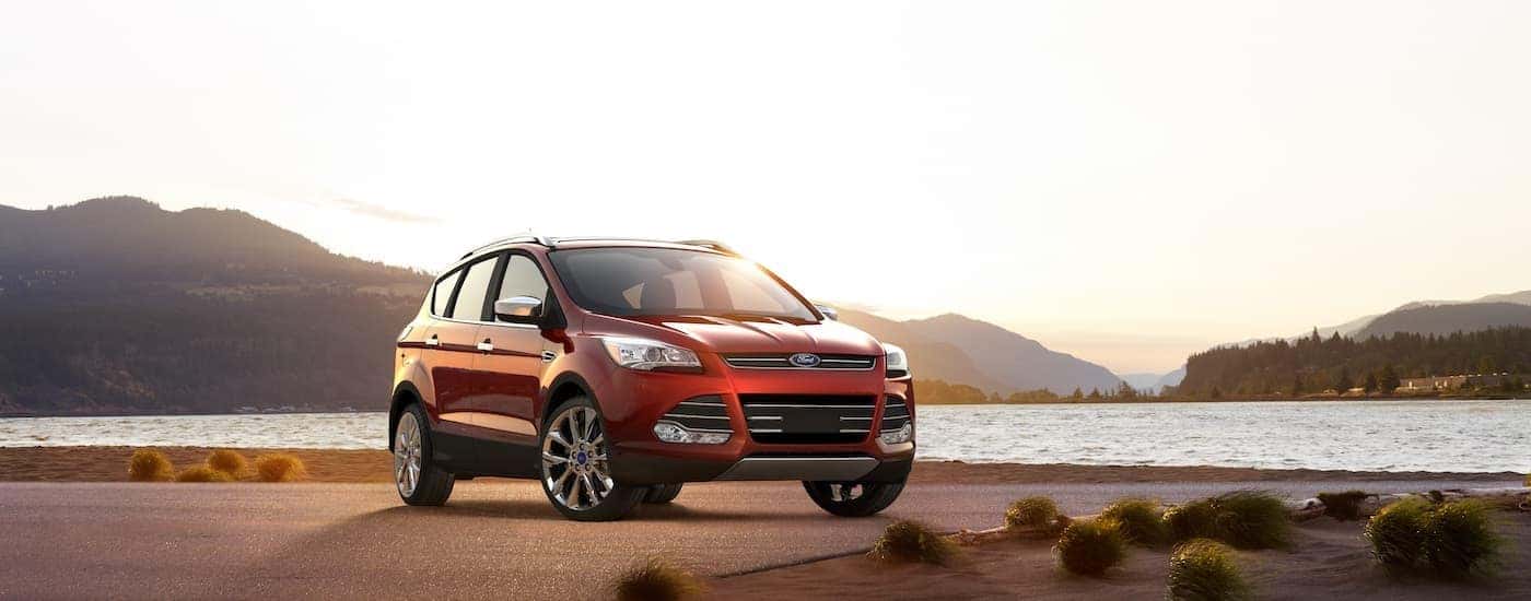 A red 2016 Ford Escape is shown parked near a lake.