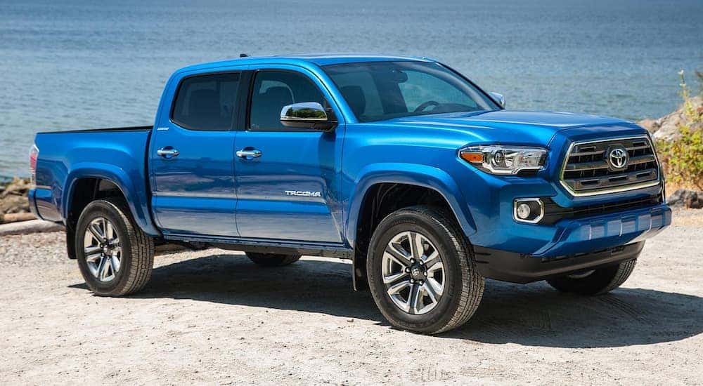 Blue 2016 Toyota Tacoma parked by a beach.