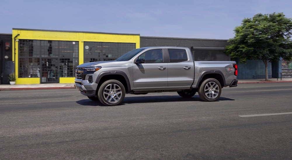 Silver 2023 Chevy Colorado Z71 driving down a city street.
