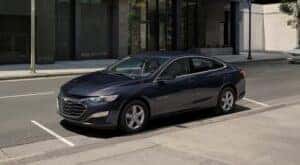 A blue 2023 Chevy Malibu is shown parked after viewing used cars for sale near Rensselaer.