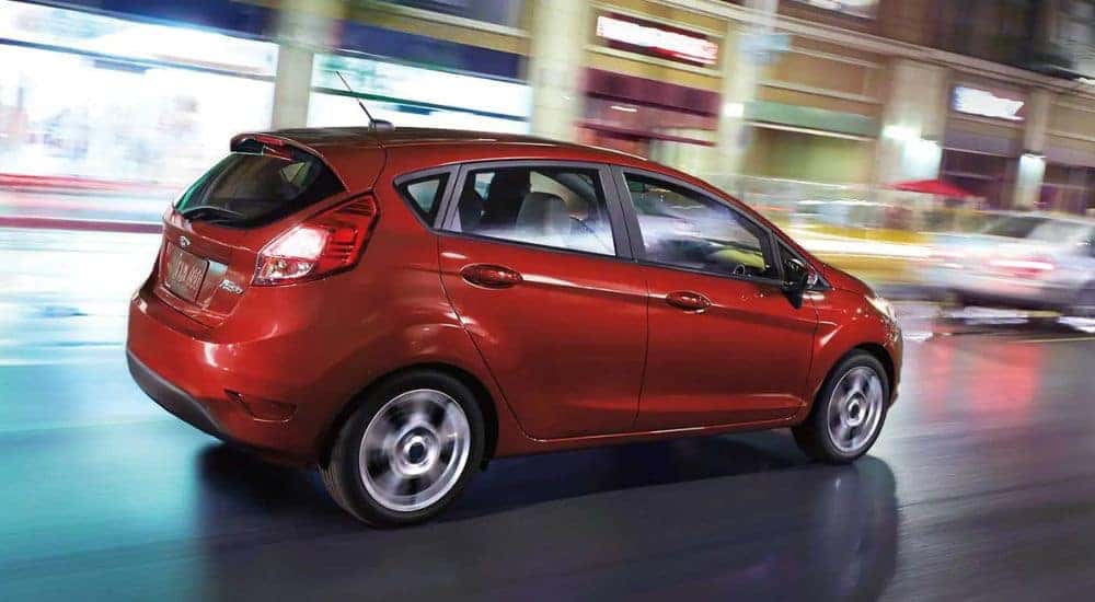 A red 2018 Ford Fiesta is shown driving on a city street.