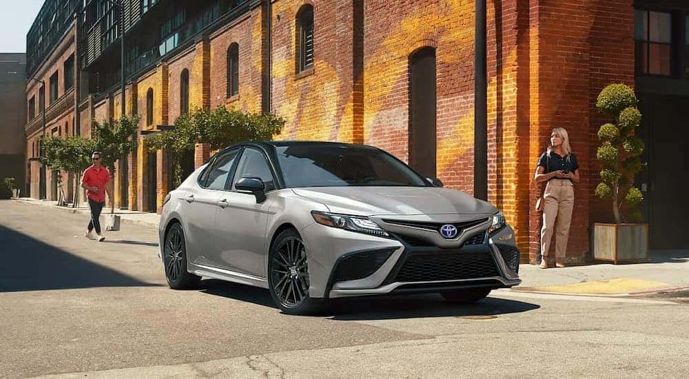 A silver 2023 Toyota Camry XSE is shown driving to view used cars for sale near Amsterdam.