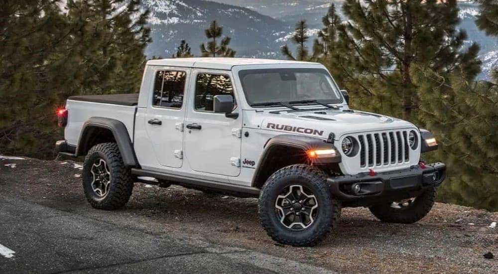 White 2023 Jeep Gladiator Rubicon parked off-road after viewing used trucks for sale in Albany.