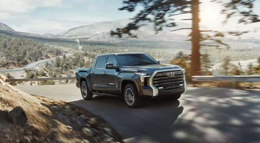 A black 2023 Toyota Tundra is shown driving uphill.