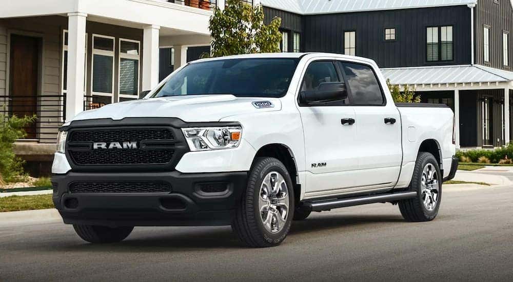 A white 2021 Ram 1500 is shown parked near a house.