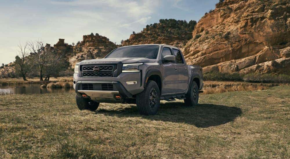 A gray 2022 Nissan Frontier is shown parked off-road.